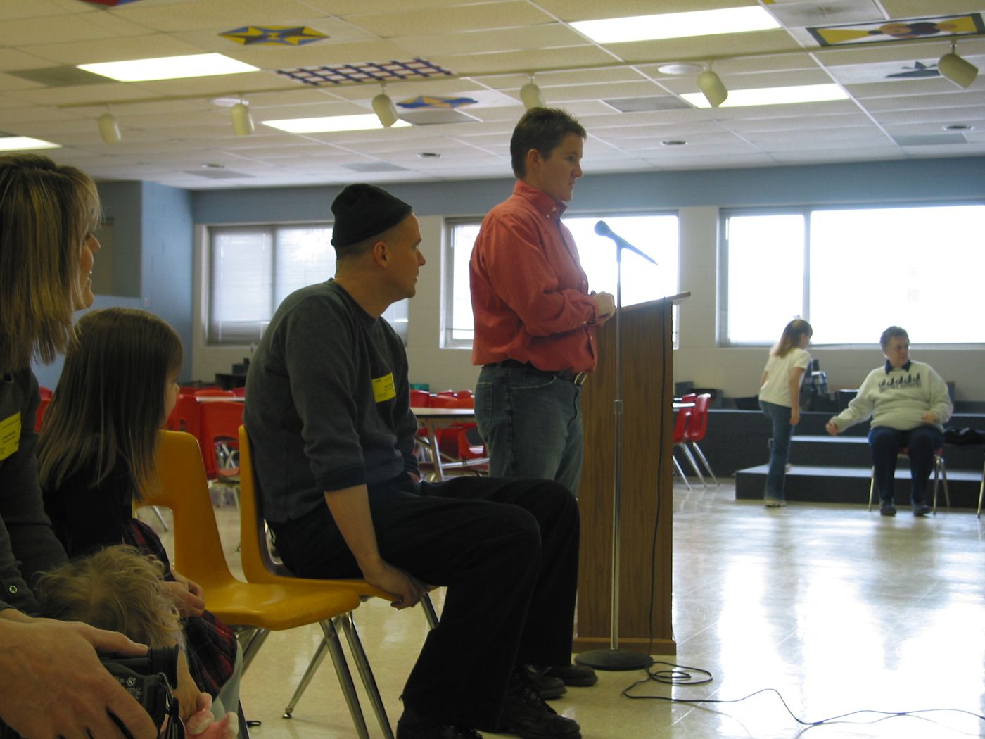 Lecture — Calvert Elementary School assembly, Lincoln, Nebraska, 2003: photograph 2 (The assembly in the school lunchroom: Matt (seated, left) is introduced)