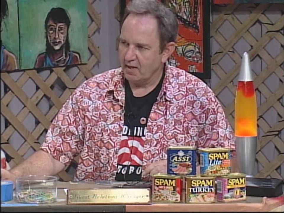 The Larz from Mars Show #125 — Matt Sesow and Dana Ellyn (2010), 2010: photograph 4 (Host Larz LaComa at his desk — Spam cans, lava lamp, a Sesow portrait behind him)