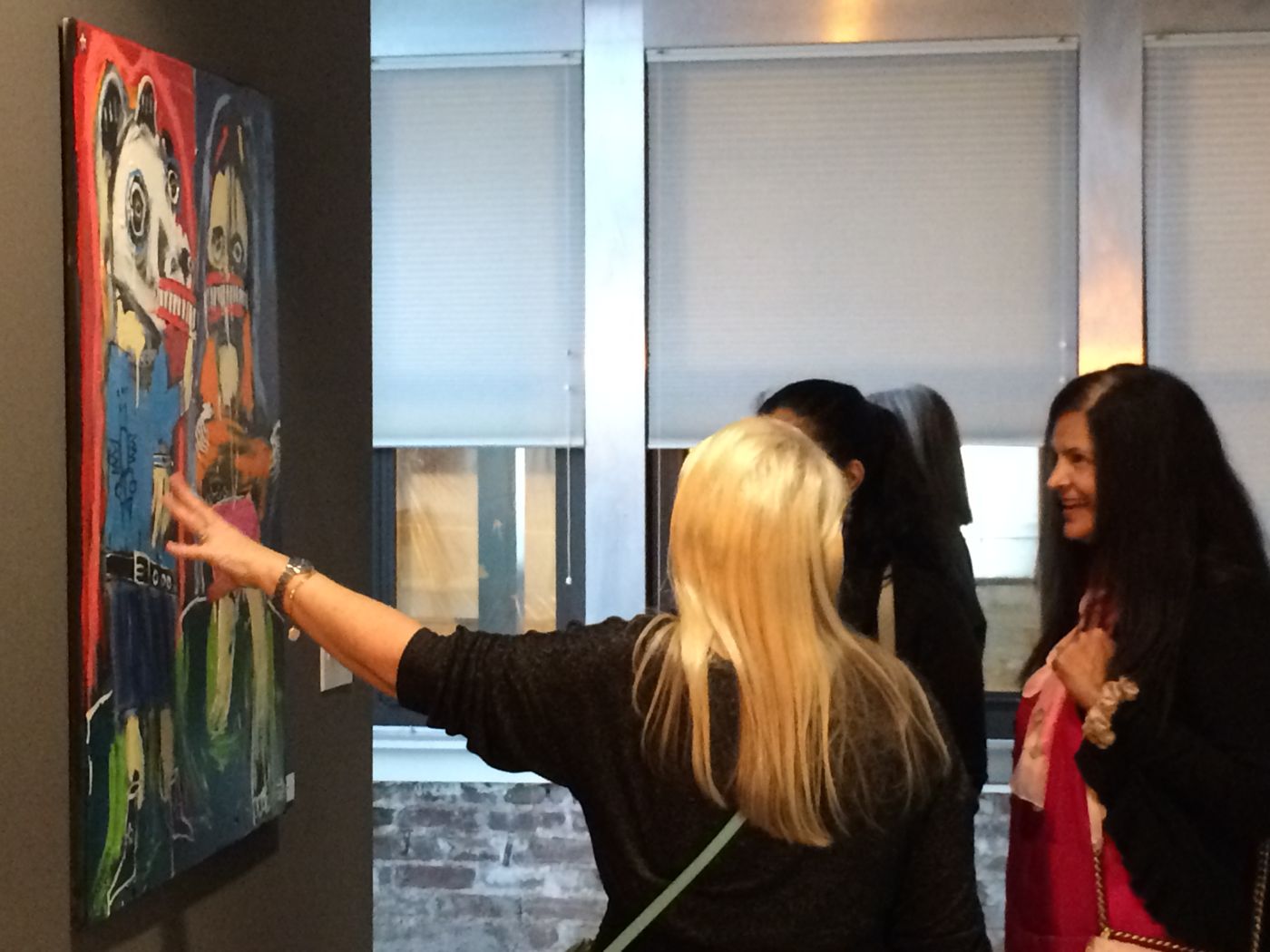 “The NO!HATE Show,” Center for Contemporary Political Art, 916 G St NW, Washington, DC, 2019: photograph 1 (Curator Robin Strogin discussing a painting by Matt Sesow at the NO!HATE Show opening, October 16, 2019)