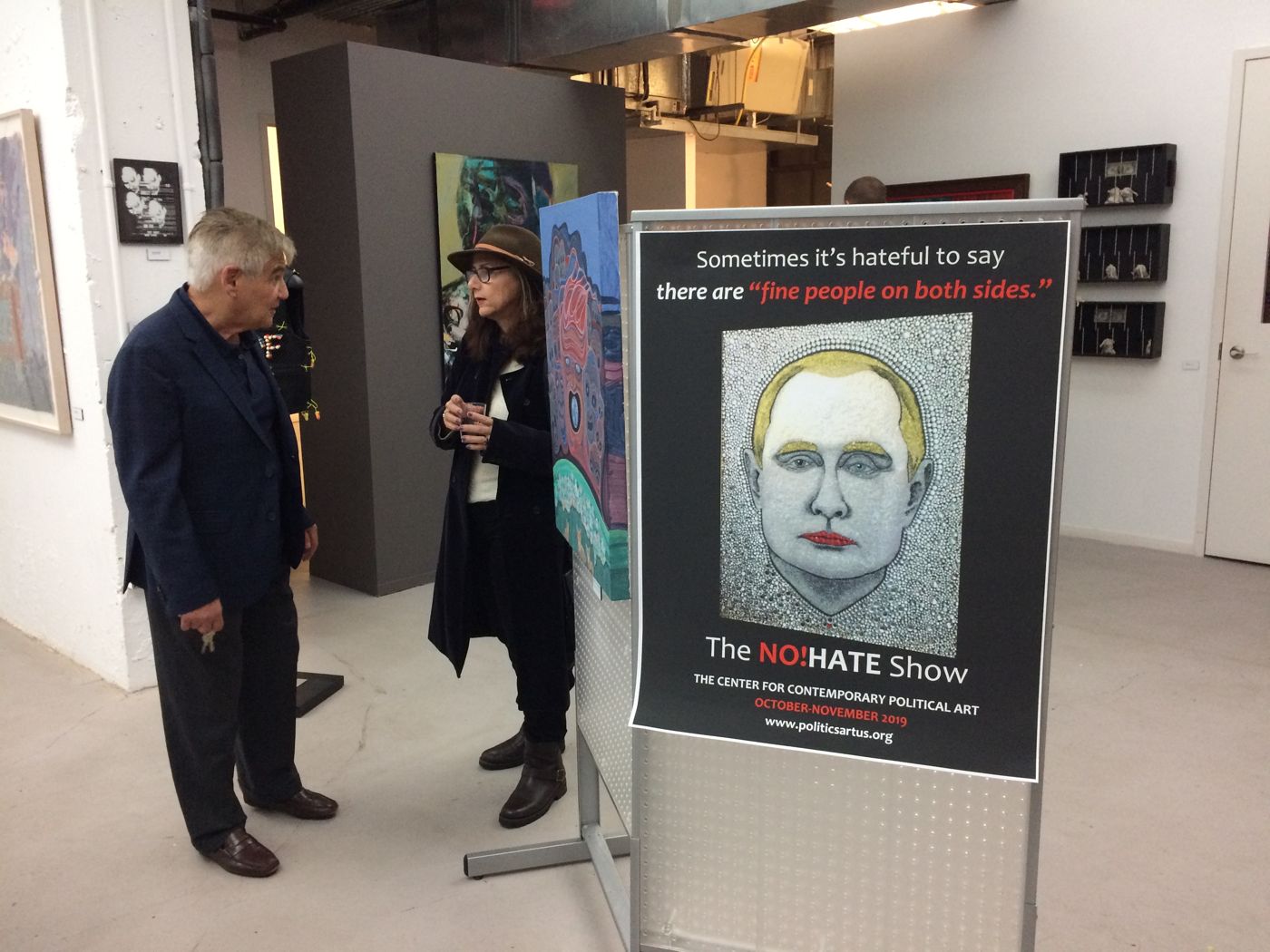 “The NO!HATE Show,” Center for Contemporary Political Art, 916 G St NW, Washington, DC, 2019: photograph 4 (Charles Krause beside the show's introduction poster)
